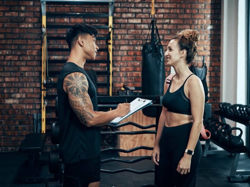 shot-of-a-sporty-young-woman-talking-to-a-fitness-trainer-at-the-gym.jpg
